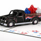 Close-up of black classic truck pop-up with patriotic bunting and layered red, white and blue stars