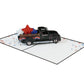 Side view of black classic truck 3D pop-up card carrying layered red, white and blue stars