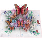 Front view of open 3D pop-up card featuring colorful butterflies, layered flowers and green foliage